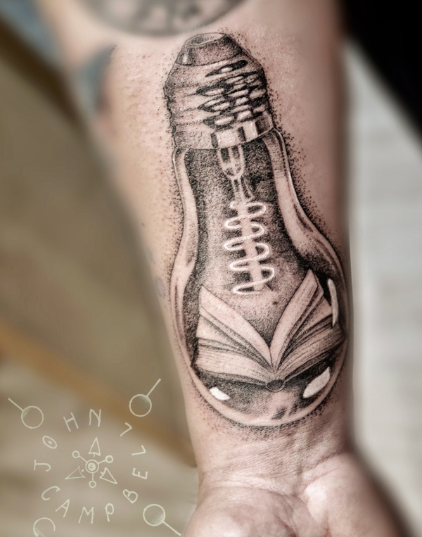 Black and grey dotwork Edison bulb with book tattoo by John Campbell at Sacred Mandala Studio tattoo parlor in Durham, NC.